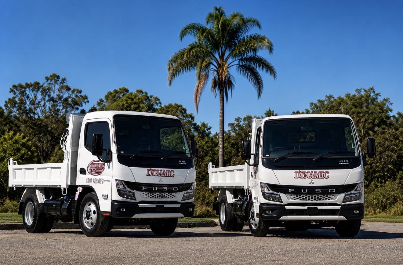 Two Dynamic-branded tipper trucks carrying matching fleet signage